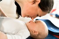Mutter ber&uuml;hrt die Nasenspitze ihres Babys mit ihrer Nase